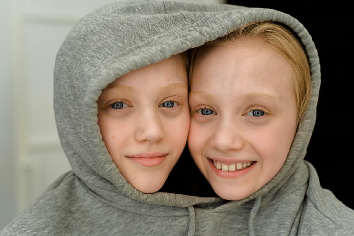 Twin children sharing a hoodie