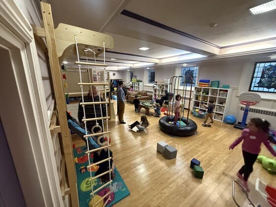 The Melrose Family Room playspace with climbing structure, toys, and families