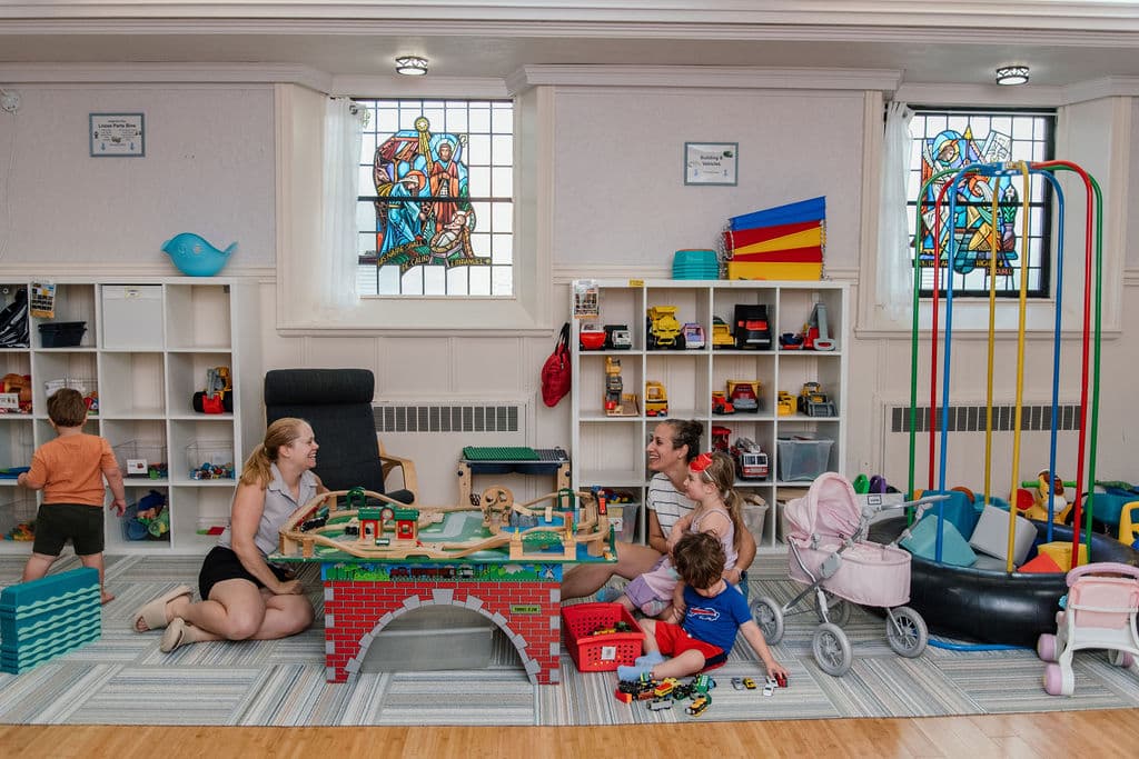 Family playing with train table at the Melrose Family Room