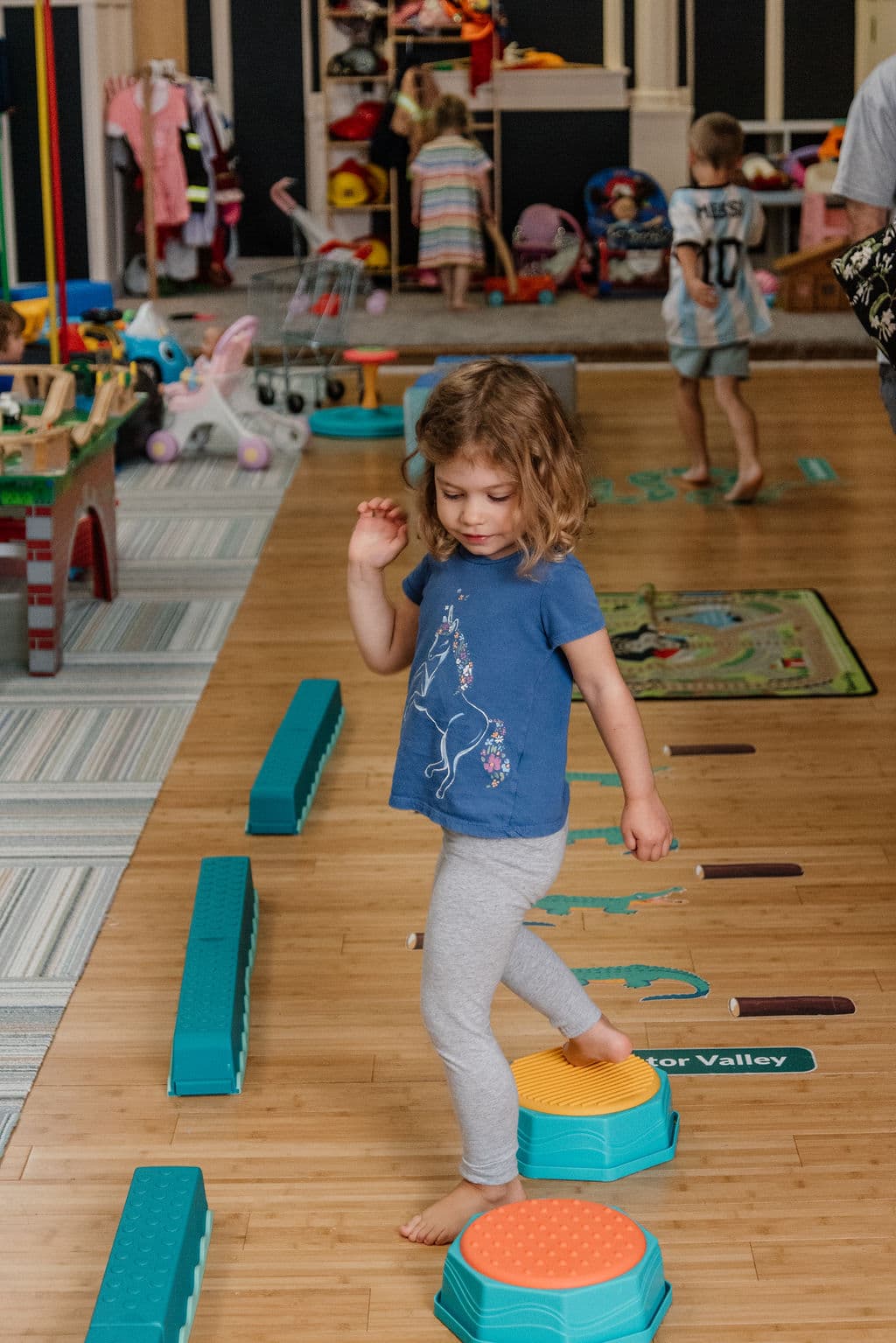 Child navigating stepping stones and balance course