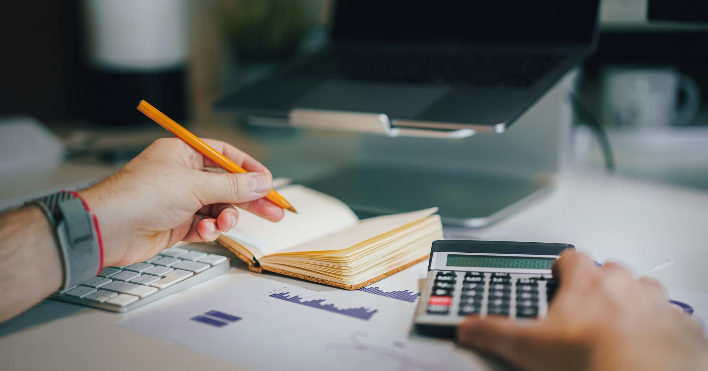 A club treasurer reconciling the books at a desk with a calculator and notebook